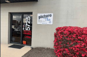Picture This framing shop entrance with red bush