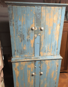 Distressed blue wooden cabinet with peeling paint