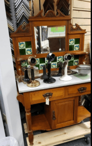 Antique wooden vanity with three candlestick telephones