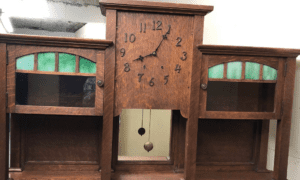 Antique wooden wall clock with green panels