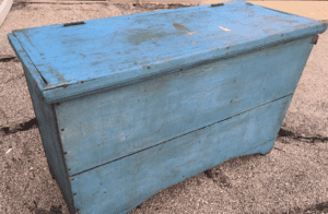 Weathered blue wooden storage chest on pavement