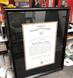 Black-framed United States Army certificate on desk