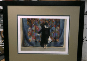 Framed art: person standing before patchwork quilt