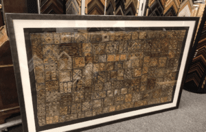 Framed decorative mosaic tile artwork leaning